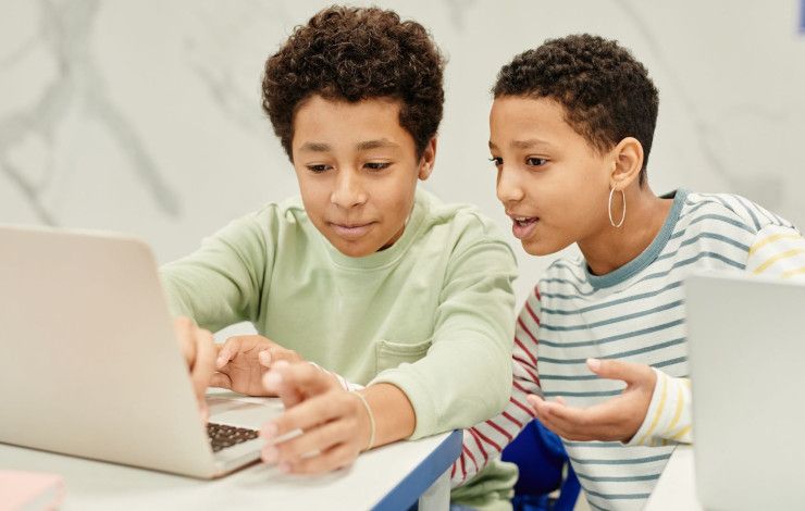 two young people using a laptop 