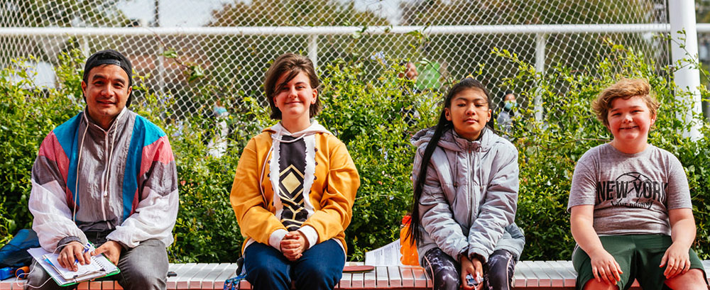 young people sitting on wall