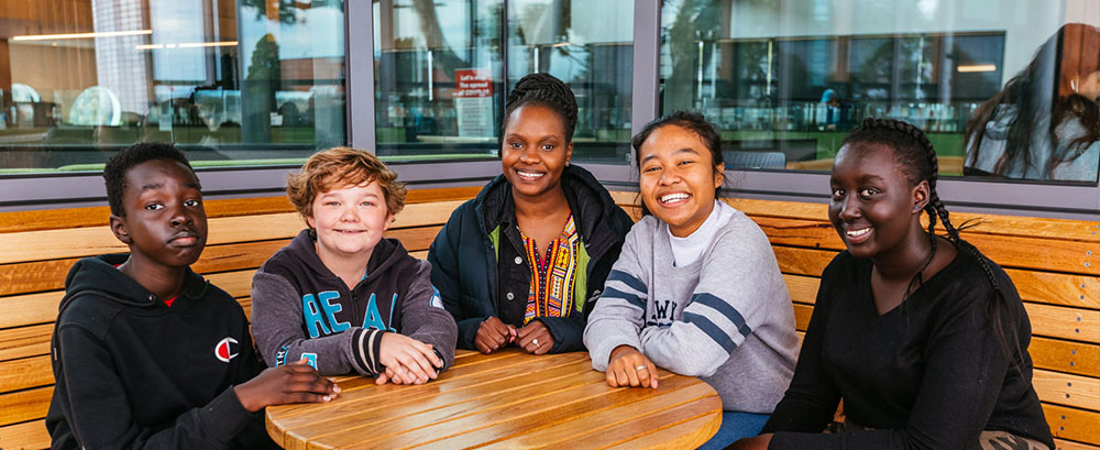 young people sitting at wooden table