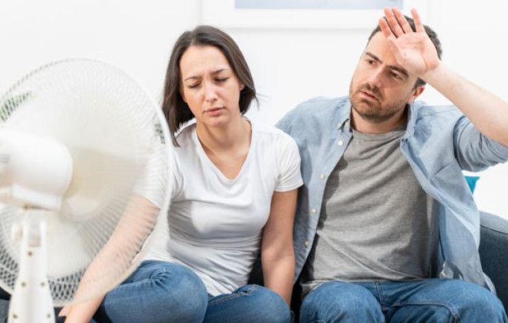 two people sitting in front of a fan