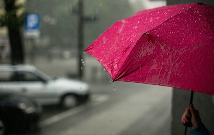 A red umbrella getting rained on.