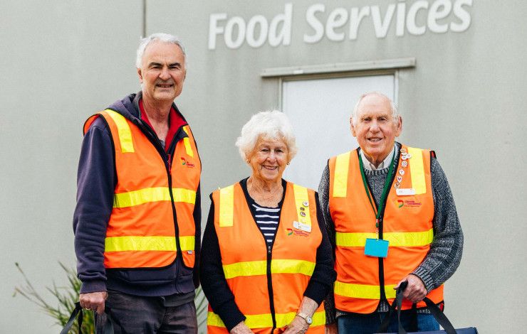 Three Meals on Wheels volunteers dressed in hi-vis vests