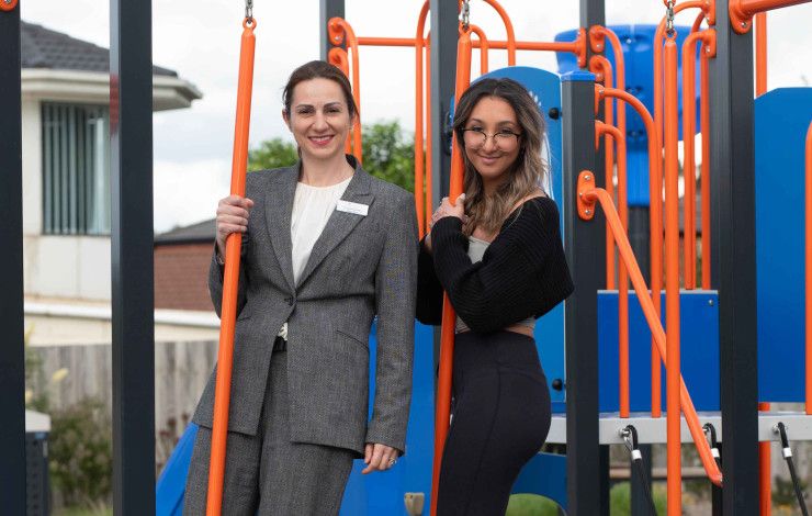 Councillor Lana Formoso with a young resident on play equipment.