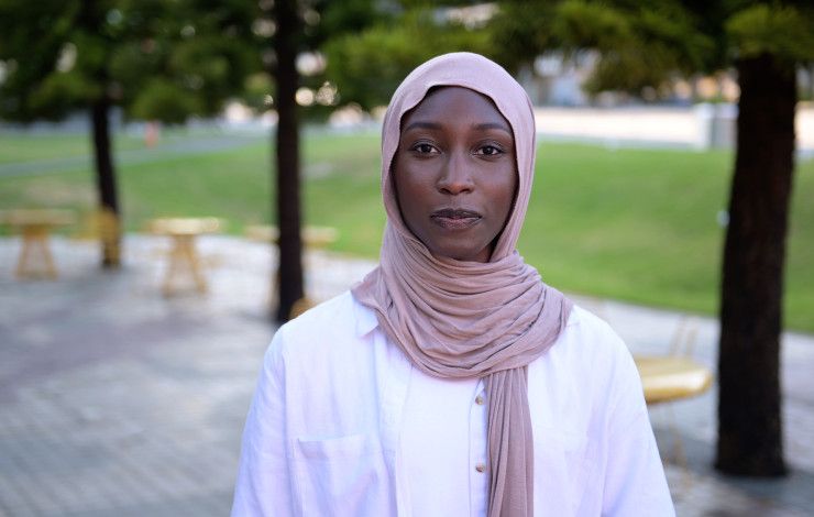 Portrait of Danya Daoud in a pink headscarf and white top.