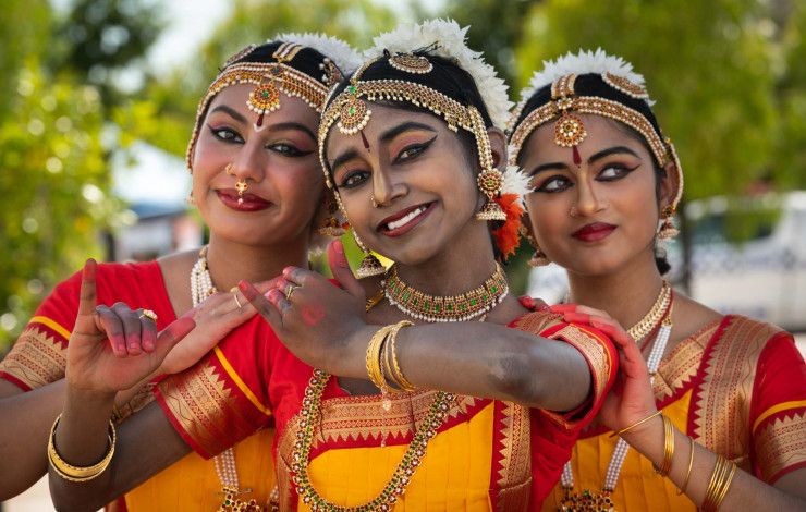 Three women in bright, traditional Indian dress.