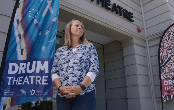 a person standing out front of Drum theatre