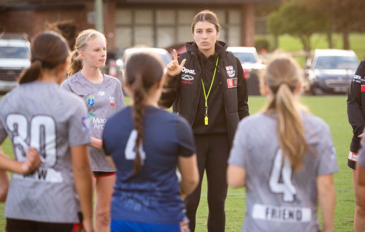 Coach and players on a sporting ground