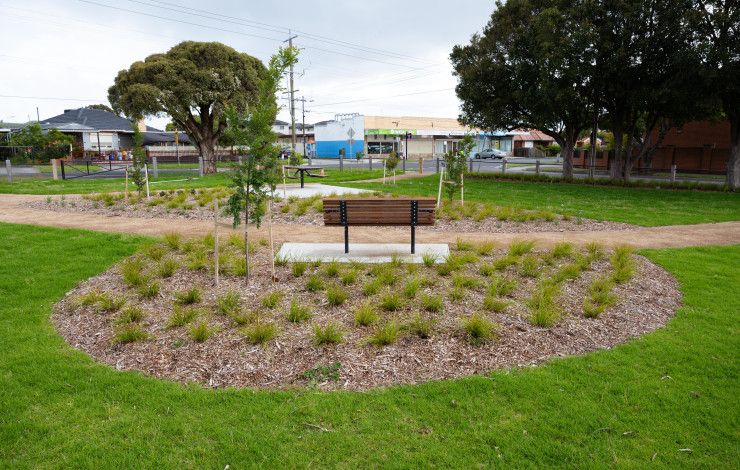 Overlooking a park bench in the middle of a grassy park