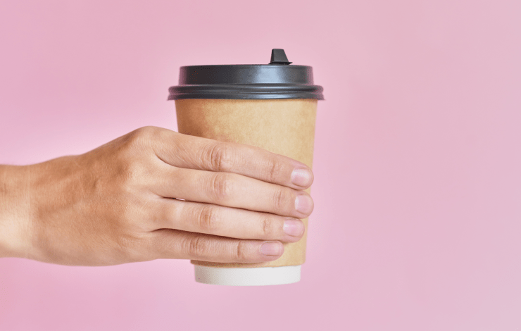 Hand holding a disposable coffee cup