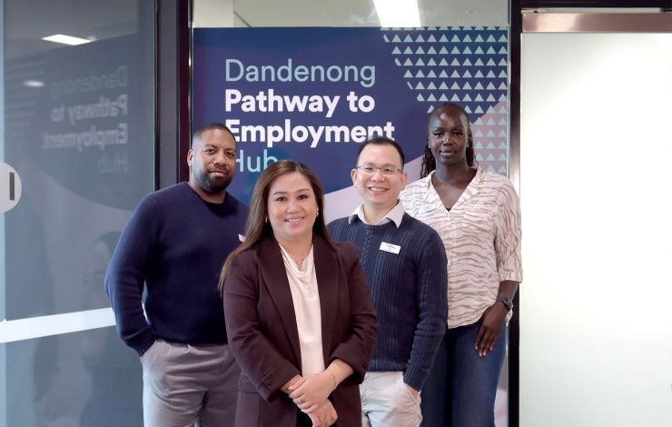 Four smiling people pose in front of a shop front with a sign that reads Dandenong Pathway to Employment Hub