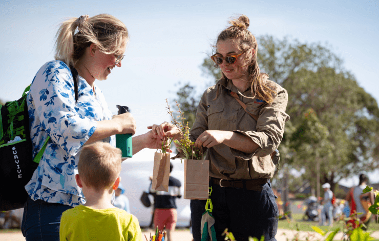 Staff memeber giving community member a plant