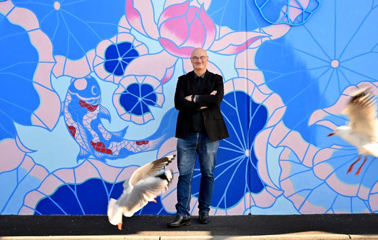 Cr Sean O'Reilly standing in front of a mural