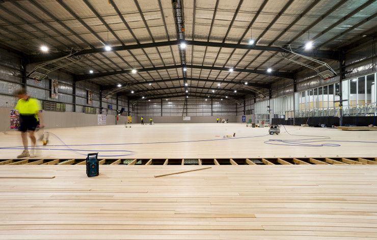 Workers complete the timber flooring at the Dandenong Stadium