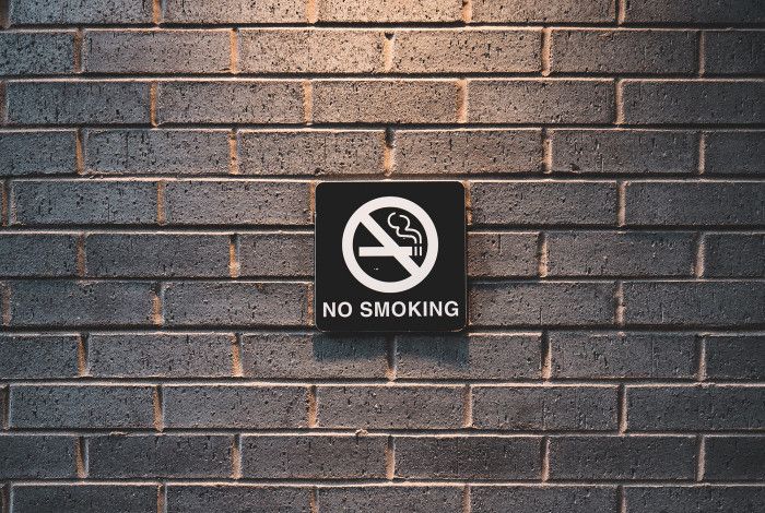 no smoking sign on brick wall