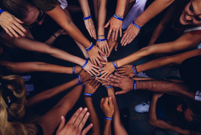 group of people put hands together