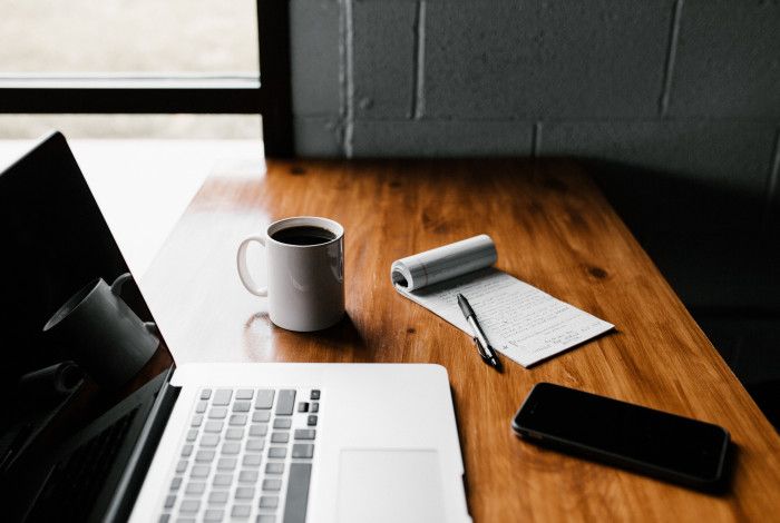 Laptop with phone, notebook and coffee cup