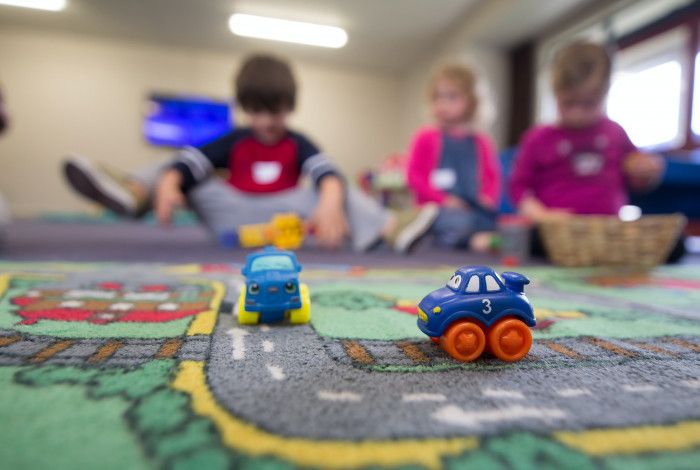 Kids playing with trucks on a rug