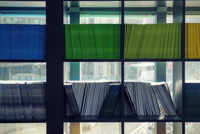 Coloured folders stacked on a book case