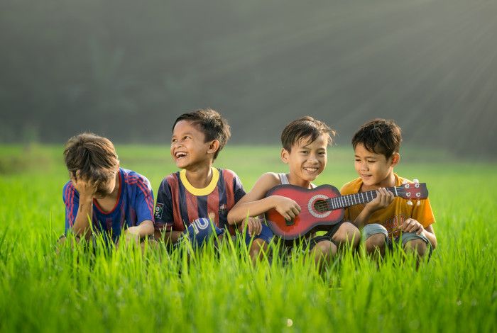 Four boys sitting in grass