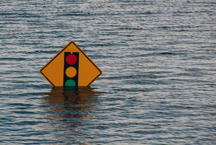 Flood water reaching traffic light sign