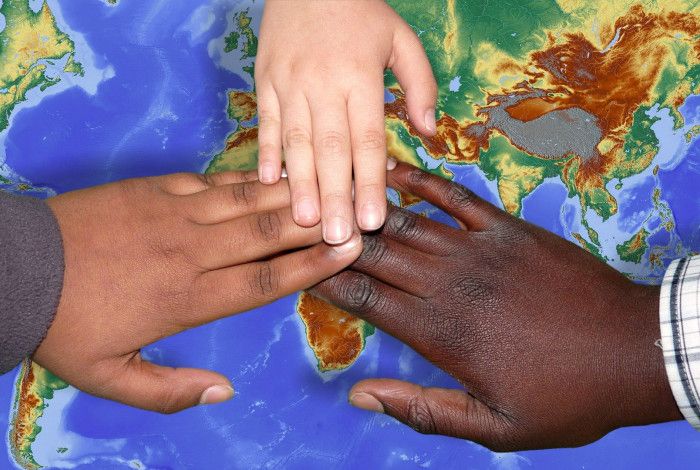 Hands united over a world map