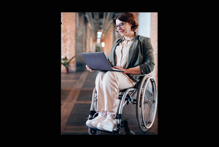 photo of woman sitting in wheelchair while using laptop