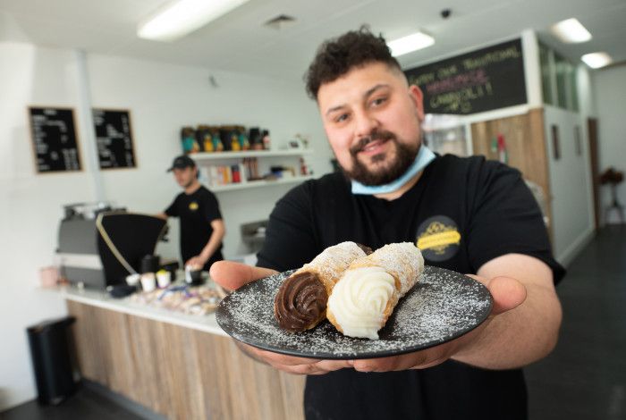 Joe holding a plate of cannoli