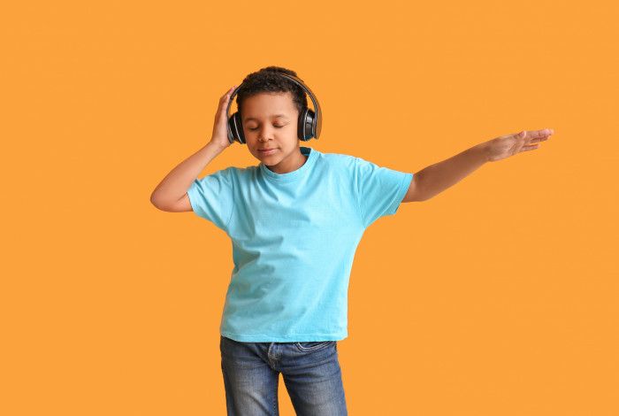 young boy dancing wearing headphone music