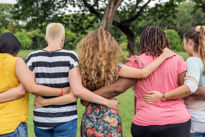 women walking in a park linking arms