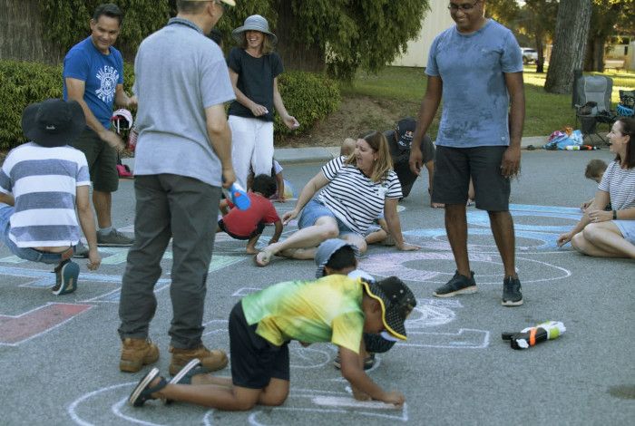 Children and parents drawing on a pavement