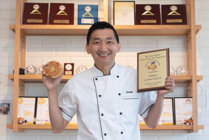 Man holding an award and a pie