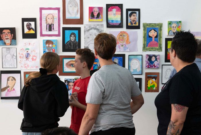 People looking at paintings on the wall