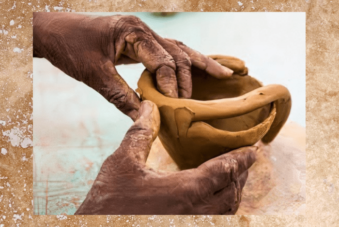 Two hands doing pottery in clay