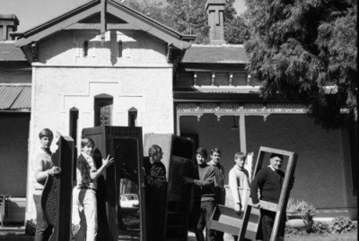 A group of people carrying furniture in a black and white image