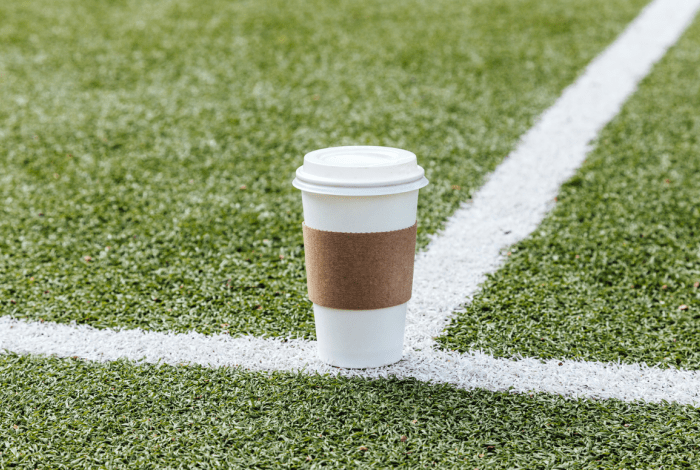 Plastic coffee cup on sports field