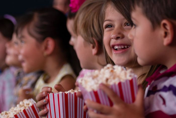 children eating popcorn at the movies