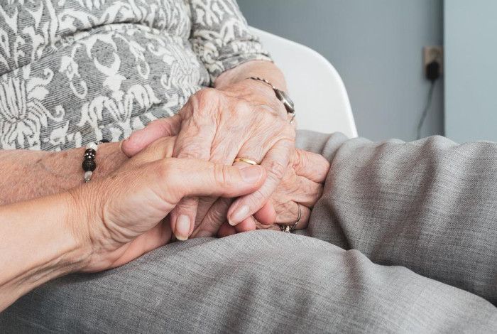 Holding hands with an elderly person