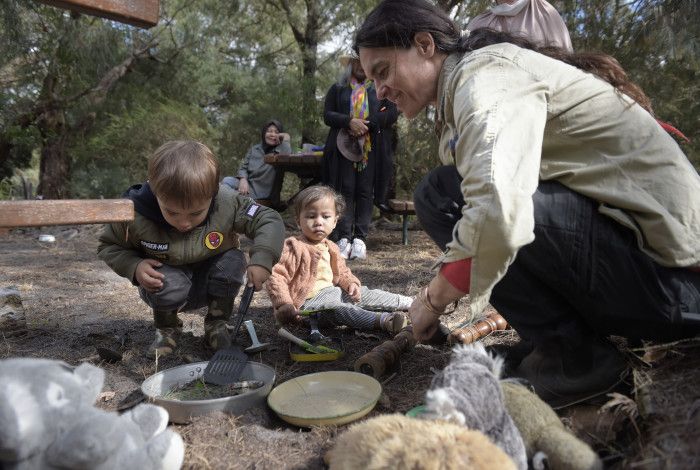an adult playing outdoors with children