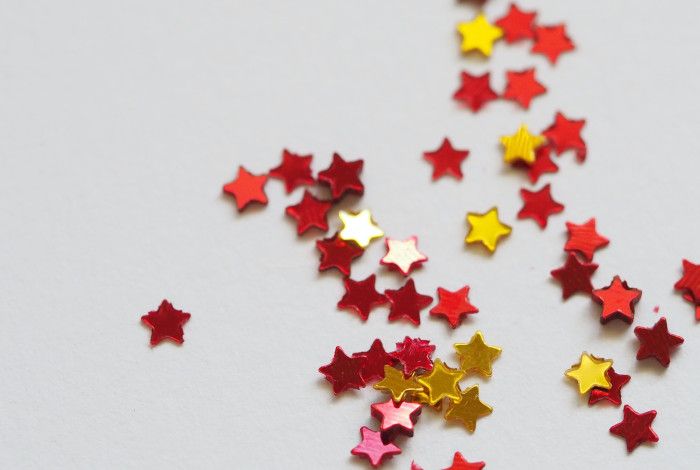 Gold and red glitter stars on a white background