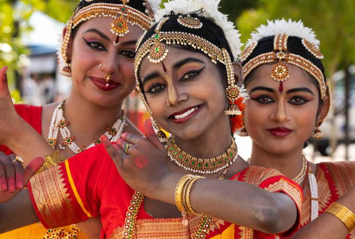 Three Kuchipudi dancers in bright-coloured traditional dress