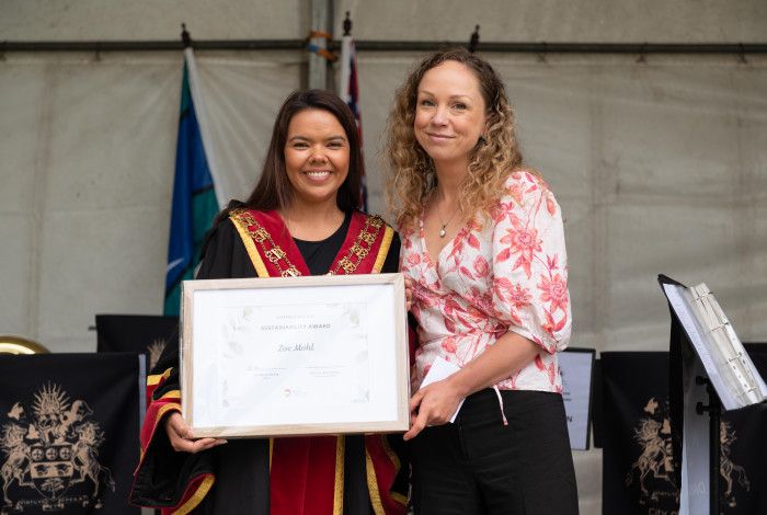 Mayor Eden Foster and Zoe Mohl holding a framed certificate