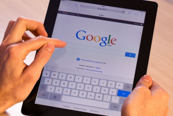 a person using a tablet device to search Google