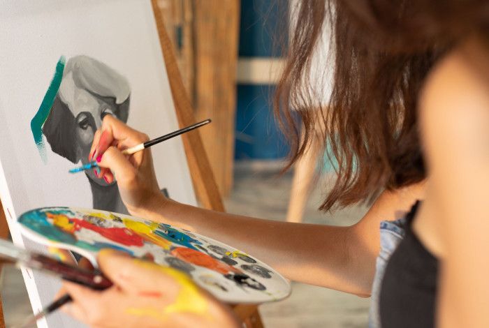 Artist painting at an eisel.