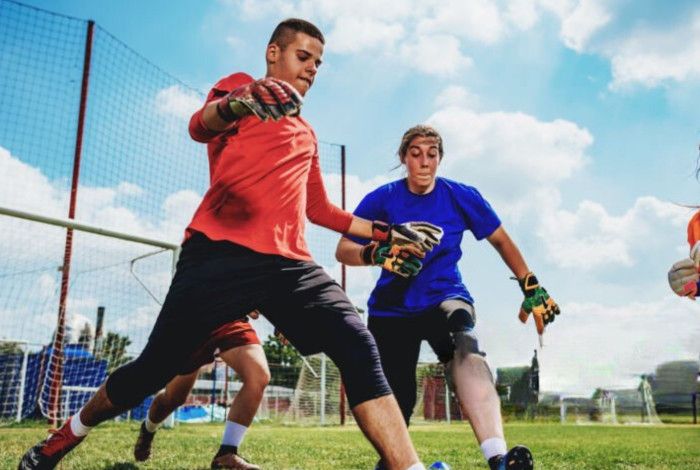 Young people playing soccer on a field.