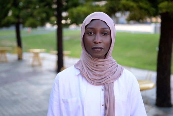 Portrait of Danya Daoud in a pink headscarf and white top.