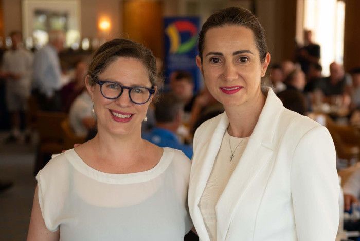 Two women dressed in white standing close together.