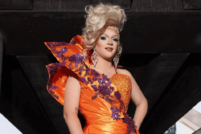 A drag queen wearing an orange dress.