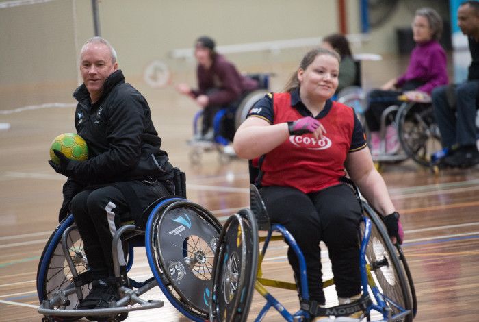 Two people in wheelchairs playing sport
