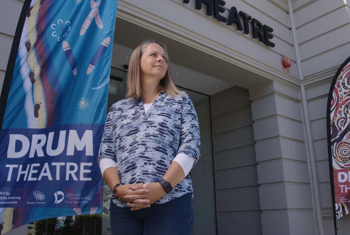 a person standing out front of Drum theatre