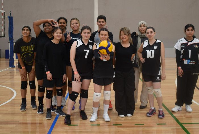young people posing with a volleyball